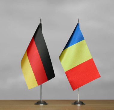 Almanya ve Romanya 'nın bayrakları gri arka planda duruyor