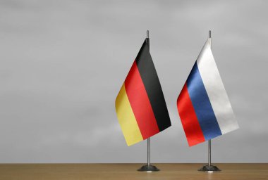 Almanya ve Rusya 'nın bayrakları gri arka planda duruyor
