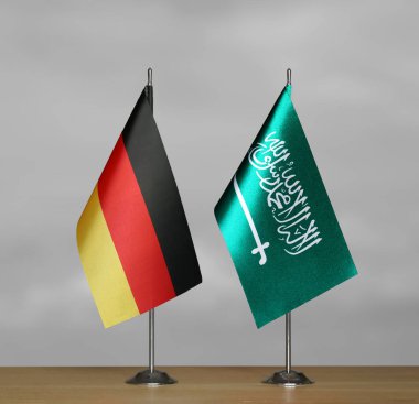 Almanya ve Suudi Arabistan 'ın bayrakları gri arka planda duruyor