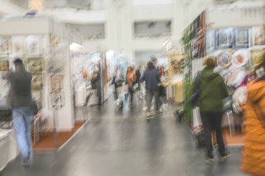 Abstract image of people in the lobby of a shopping center with a blurred background