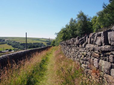 narrow country lane going down a hill in scenic west yorkshire countryside near colden village in calderdale west yorkshire