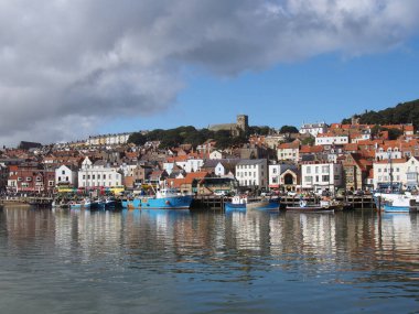 Scarborough, Kuzey Yorkshire, İngiltere - 12 Eylül 2022: Limanda demirlemiş teknelerle birlikte yazın Scarborough kasabasının manzarası
