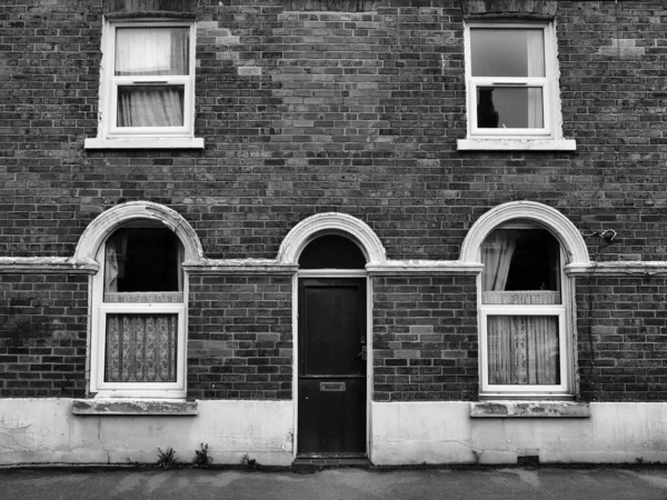 典型的有白色窗户和网幕的英国古老砖造露台房屋的前景 — 图库照片