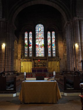 Chester. Cheshire, United Kingdom - 20 March 2024 : The alter and stained glass windows in St John the Baptist's Church, Chester clipart