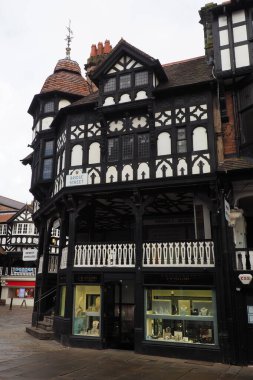 Chester mı? Cheshire, Birleşik Krallık - 20 Mart 2024: Eastgate 'in köşesindeki eski ahşap binalar ve üst sıralara çıkan merdivenler