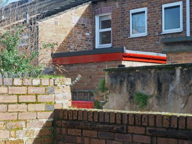 view of a back alley from a yard with brick walls in a typical old english working class terraced street clipart