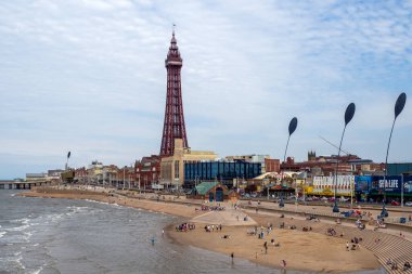 Blackpool, Lancashire, İngiltere - 26 Haziran 2024: Central Blackpool 'da turistik merkezli deniz önü ve plajda insanlarla dolu kule