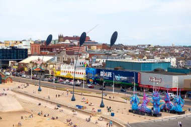 Blackpool, Lancashire, United Kingdom - 27 July 2024 : aerial view of the seafront at Blackpool with funland, sealife, golden mile amusements and coral island with the sea grass sculpture and people on the beach in summer clipart