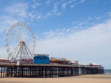 Blackpool, Lancashire, Birleşik Krallık - 27 Temmuz 2024: Dönme dolabı olan Blackpool merkez iskelesi ve yaz güneşinin alçaldığı sahilde at sürüyor