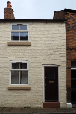 Tipik bir 19. yüzyıl ön cephesi. Küçük İngiliz sarı boyalı, beyaz pencereli ve siyah kapılı bir ev.