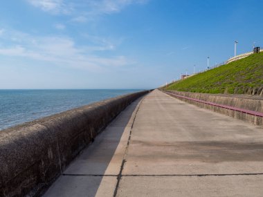 Kuzey Blackpool 'daki uzun yaya geçidi yaz güneşinde deniz yükselirken.