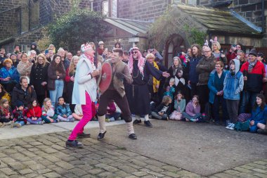 Hebden Köprüsü, Batı Yorkshire, Birleşik Krallık - 29 Mart 2024: Heptonstall West Yorkshire 'daki Weaver Meydanı' nda geleneksel iyi Cuma temposunda oyuncular ve seyirciler