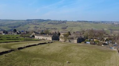 Yeşil ağaçların ve hayvanların olduğu güzel bir kır manzarası.