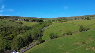 Yeşil ağaçlar ve tarlalarla güzel bir kır manzarası.