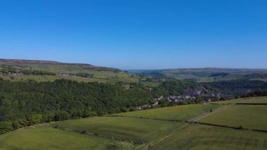 Yeşil ağaçlar ve tarlalarla güzel bir kır manzarası.