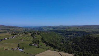Hebden Köprüsü yakınlarındaki kırsal alanda panoramik hava aracı görüntüsü uzaktaki Hebden Köprüsü ile Heptonstall ve Batı Yorkshire manzarasını gösteriyor.     