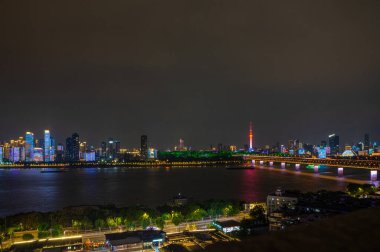 Çin, Wuhan 'ın iki nehri ve dört kıyısındaki tarihi şehrin gece manzarası.