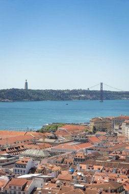 Lizbon çatılarında Ponte 25 de Abril köprüsü ve Santuario de Cristo Rei arka planda, Portekiz
