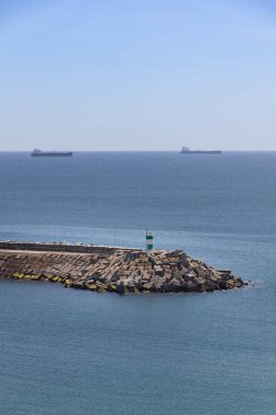 Güneşli bir yaz gününde, Portekiz Sines Limanı 'ndaki yeşil deniz feneri.