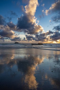 Beautiful Muriwai Beach covered with clouds at sunset clipart