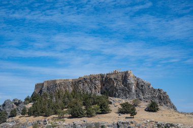 Hilltop Lindos acropolis located on Greek island of Rhodes captured on a sunny day clipart