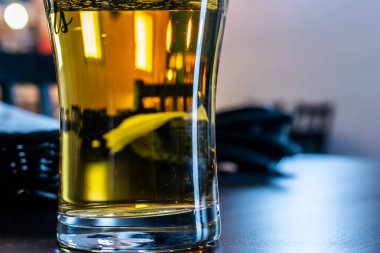 Karışık bir masanın arka planında bir kupa bira.