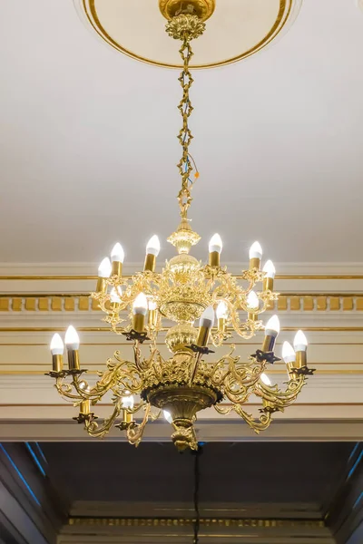 chandelier in gold on the background of a white ceiling