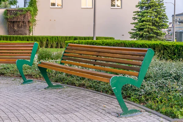人行道上的绿色和棕色长椅 — 图库照片