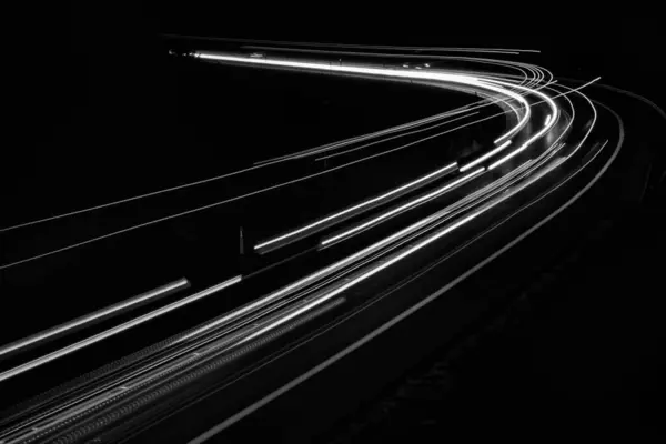 黒い背景の車のライトの白い線 — ストック写真