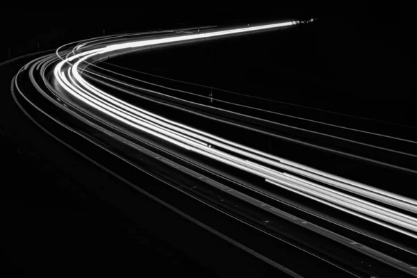 黒い背景の車のライトの白い線 — ストック写真