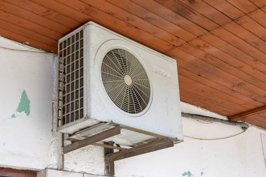 Klima duvarın arkasında, çatının altında asılı.