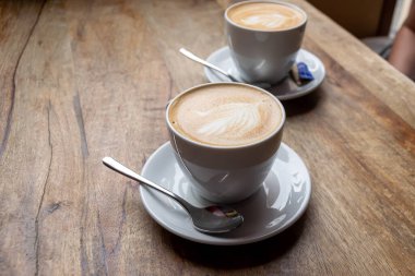 Masanın üzerinde beyaz bardaklarda kahve.