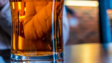  Karışık bir masanın arka planında bir kupa bira.