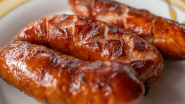 Ev portatif ızgarada ızgara sosis, pastırma ve soğan.