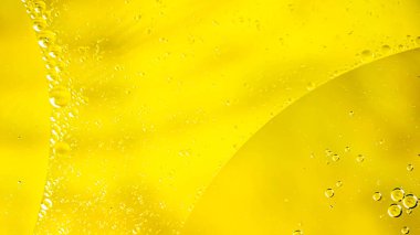 Sarı zemin üzerindeki suya yağ damlaları