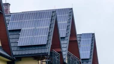 Siyah metal çatı fayanslarının üzerindeki fotovoltaik paneller