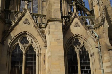 Architectural details of the Johannes Church in Stuttgart. The bright sandstone glows in the spring sun and the masterful stonework is made to shine. Rosettes, retaining walls and the stained glass windows inspire the viewer.