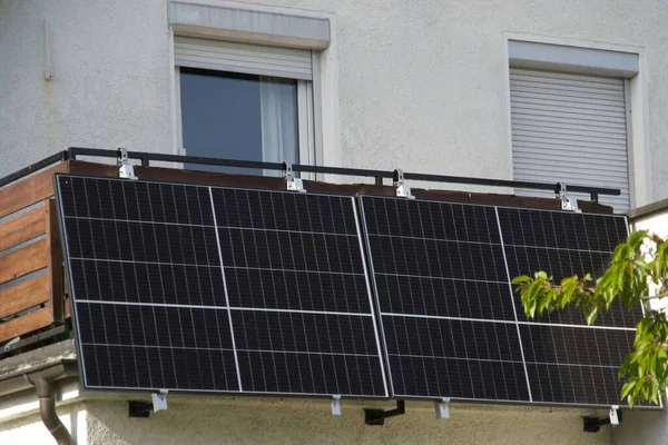 stock image Solar modules on the railing of a larger terrace. The delicate branches of a cherry tree tower over a panel. A synonym for life in the countryside