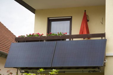 Güneş enerjisi santrali bir balkon korkuluğu üzerinde çiçek kutuları ile