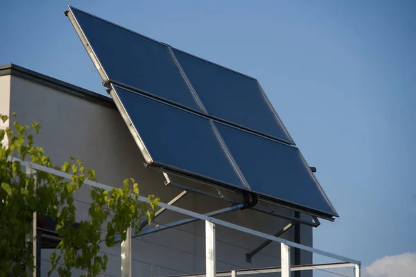 屋根のテラスに設置された大きなバルコニー発電所 太陽電池モジュールは 多くの光を捕捉するために角度に取り付けられています 明るい太陽とほぼ雲のない空は高い電力生産を保証します — ストック写真