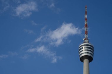 Parlak gün ışığında Stuttgart TV kulesi. Kule gerçek anlamda bir gökdelendir. Yırtık bulutlar kule sepetinin ve yüksek antenin yüksekliğinde. Televizyon kulesi eyalet başkenti Stuttgart 'ın bir simgesidir.