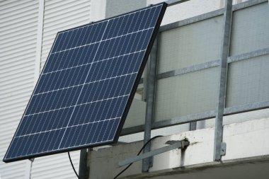 Balcony power station on the railing of a modern apartment building clipart