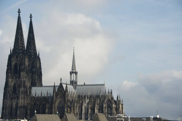 科隆大教堂的高塔俯瞰全景 大教堂耸立在附近所有的住宅屋顶上 但与天空中巨大的云山相比 哥特式建筑似乎很小 — 图库照片#