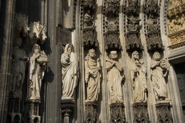 Köln Katedrali 'nin ana kapısındaki heykeller. İfade eden figürler, sütun başkentlerinde ziyaretçilerin kafalarının üzerinde yüksekte duruyor. Musa 'yı 10 emirden oluşan tabletlerle görebilirsiniz. Ve tabii ki Nuh' u da. Gemisinin bir modelini elinde tutuyor.