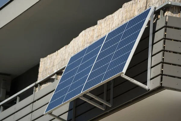 两个太阳能组件作为阳台上的发电厂 在一个公寓的栏杆上方的观众的头上 阳光照射在面板上 保证了高产量 — 图库照片#