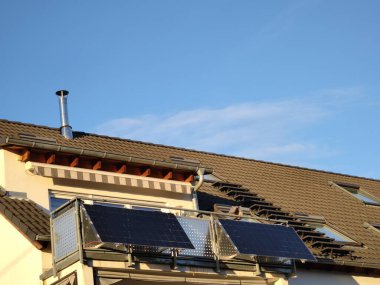 Güneş modülleri üst kattaki bir dairenin balkonuna çapraz olarak monte edilir ve akşam ışığı tarafından aydınlatılır.