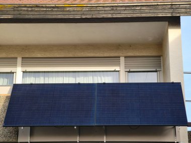 4 solar modules are mounted diagonally in front of a balcony railing and use the entire length of the balcony clipart