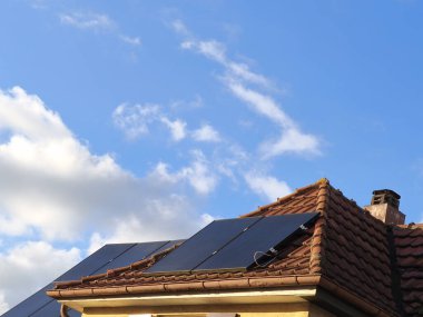 Küçük koy penceresindeki güneş panelleri ve tarihi evin arkasındaki çatı. Güneş modülleri güneş tarafından aydınlatılır. Artık çok elektrik üretiliyor.