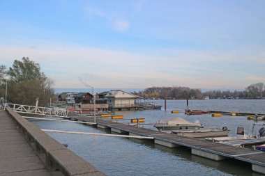 Tekneler, ağaçlar ve ahşap evlerle dolu bir nehirde mavi bir sonbahar günü..