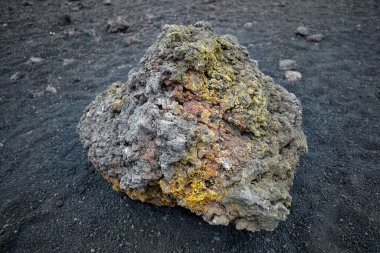 Volkanik atıklar, lavlar, İtalya, Sicilya 'daki Etna Yanardağı' nın volkanik kayasında sülfür kalıntıları olan renkli taşlar.